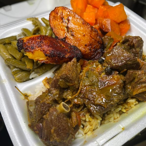 Soul food plate with stewed meat, rice, green beans, fried plantains, and sweet potatoes.