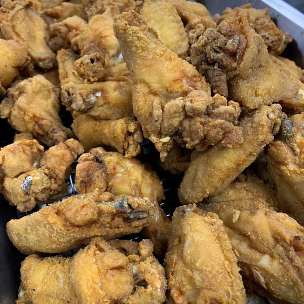 Close-up of golden-brown fried chicken pieces, likely from Let's Eat Soul Food.