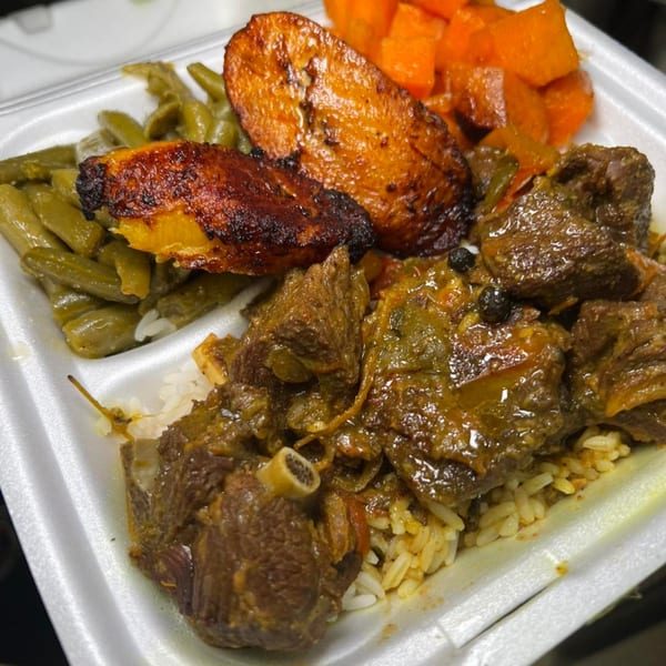 A soul food meal in a styrofoam container with stewed meat, rice, green beans, and candied yams.